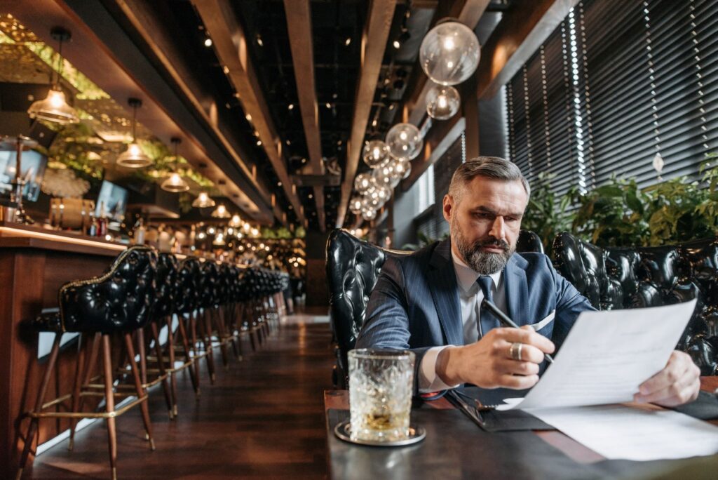 Man signing documents in a bar as an alternative work space.