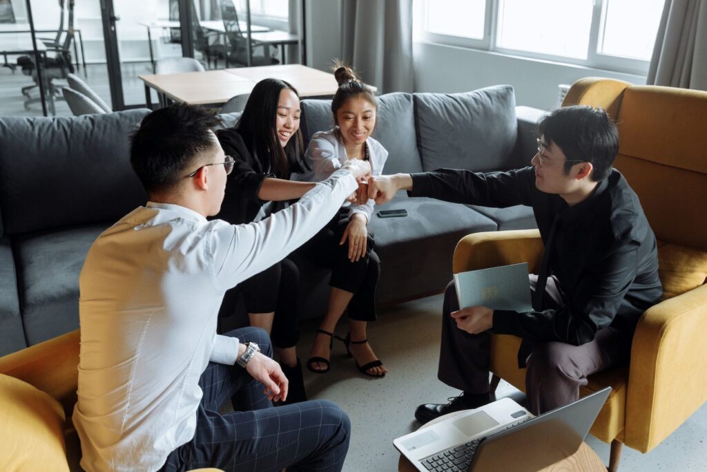 In an office lounge, four talented individuals collaborate on a project.