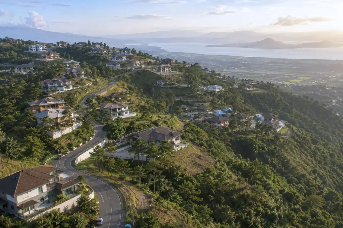 Residential community of modern tropical ridge houses arranged along hillside terrain within a Philippine highland development.