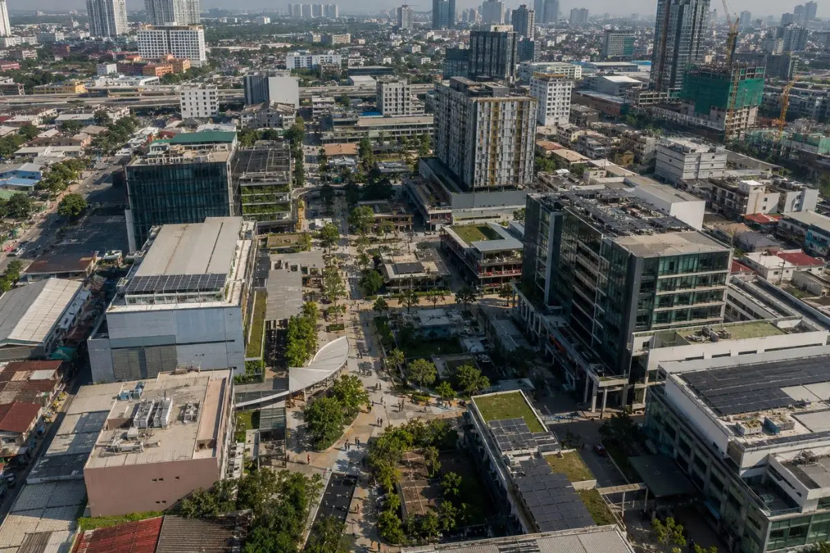 An aerial view of a mixed-use innovation district integrating offices, research facilities, residential buildings, public spaces, and pedestrian-friendly streets within a dense Philippine urban environment.
